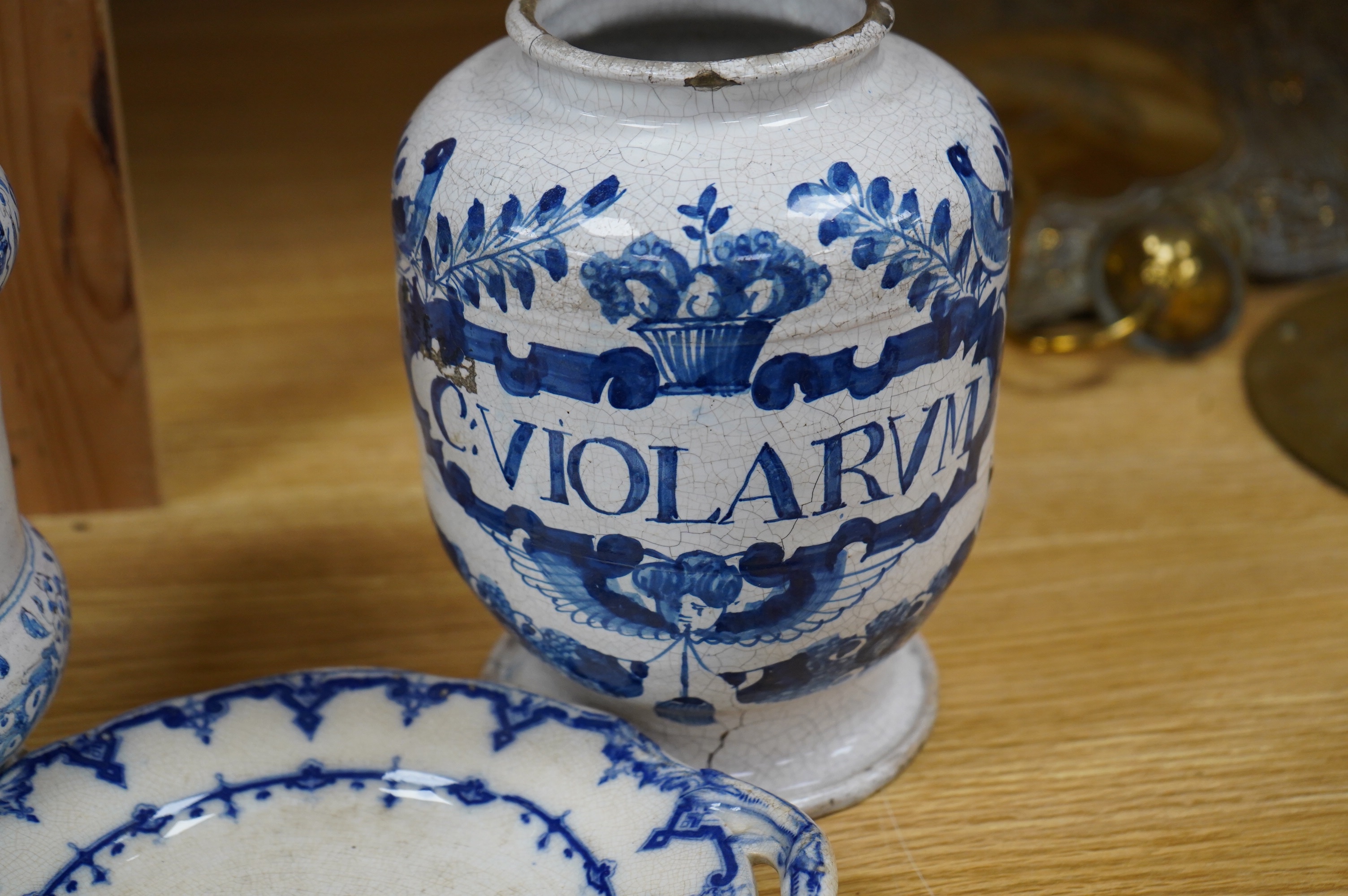 A 17th /18th century blue and white Delft apothecary jar, together with an Italian blue and white pottery drug jar and a blue and white ‘Saxon Star’ two handled dish, tallest 19cm. Condition - poor